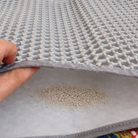 Placeholder: double layer litter mat lifted to show trapped litter