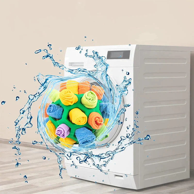 Placeholder: snuffle ball dog toy with water splash in front of washing machine, machine washable